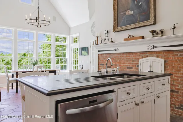 a open kitchen with granite countertop a stove a sink and a fireplace