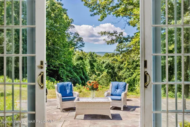 a view of a porch with chairs and potted plants