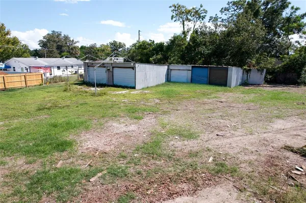 a large green field with lots of trees in the background