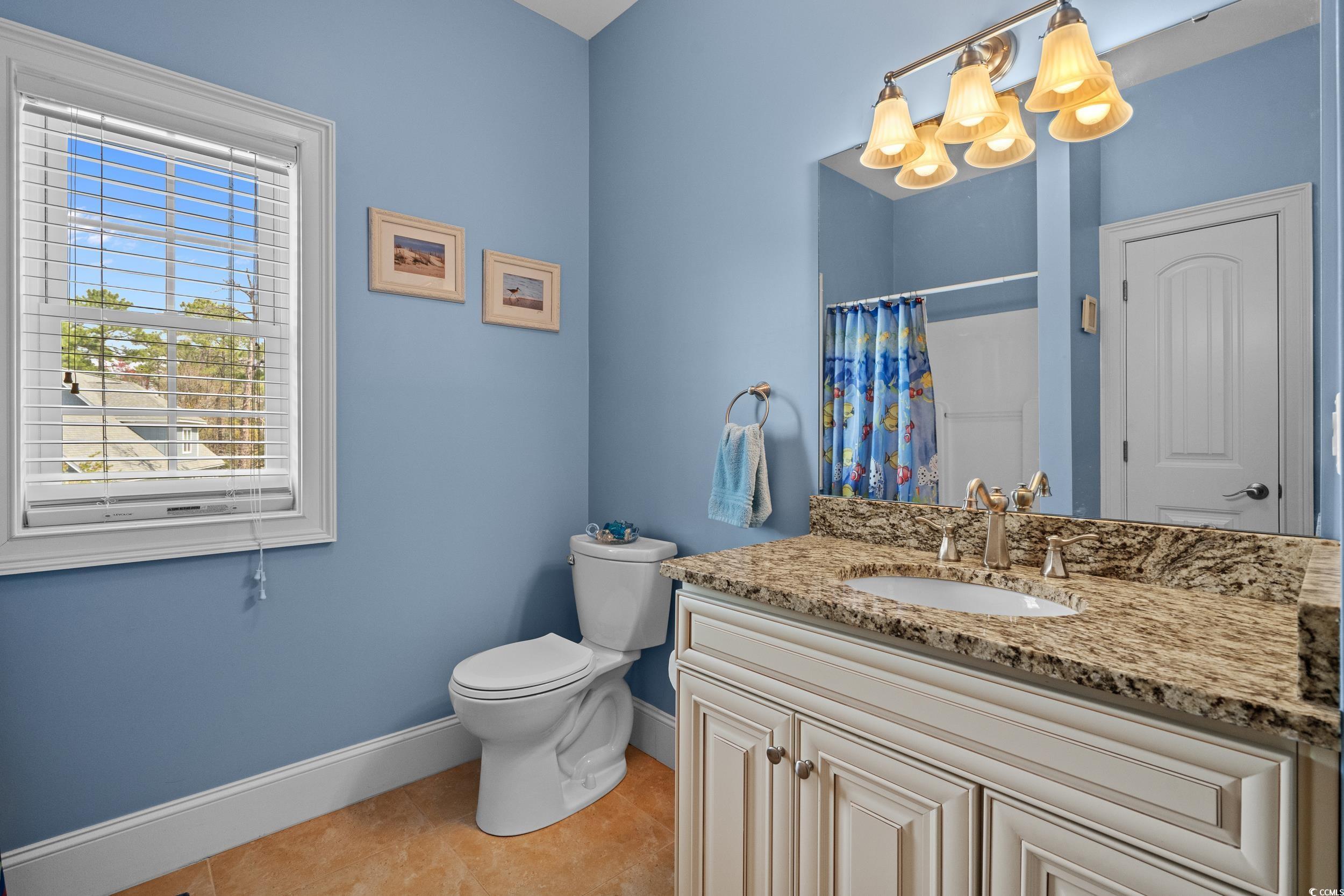416 Seabury Lane Myrtle Beach, SC 29579 - Photo 23 of 39 Bedroom featuring baseboards, ensuite bath, ceiling fan, visible vents, and wood finished floors