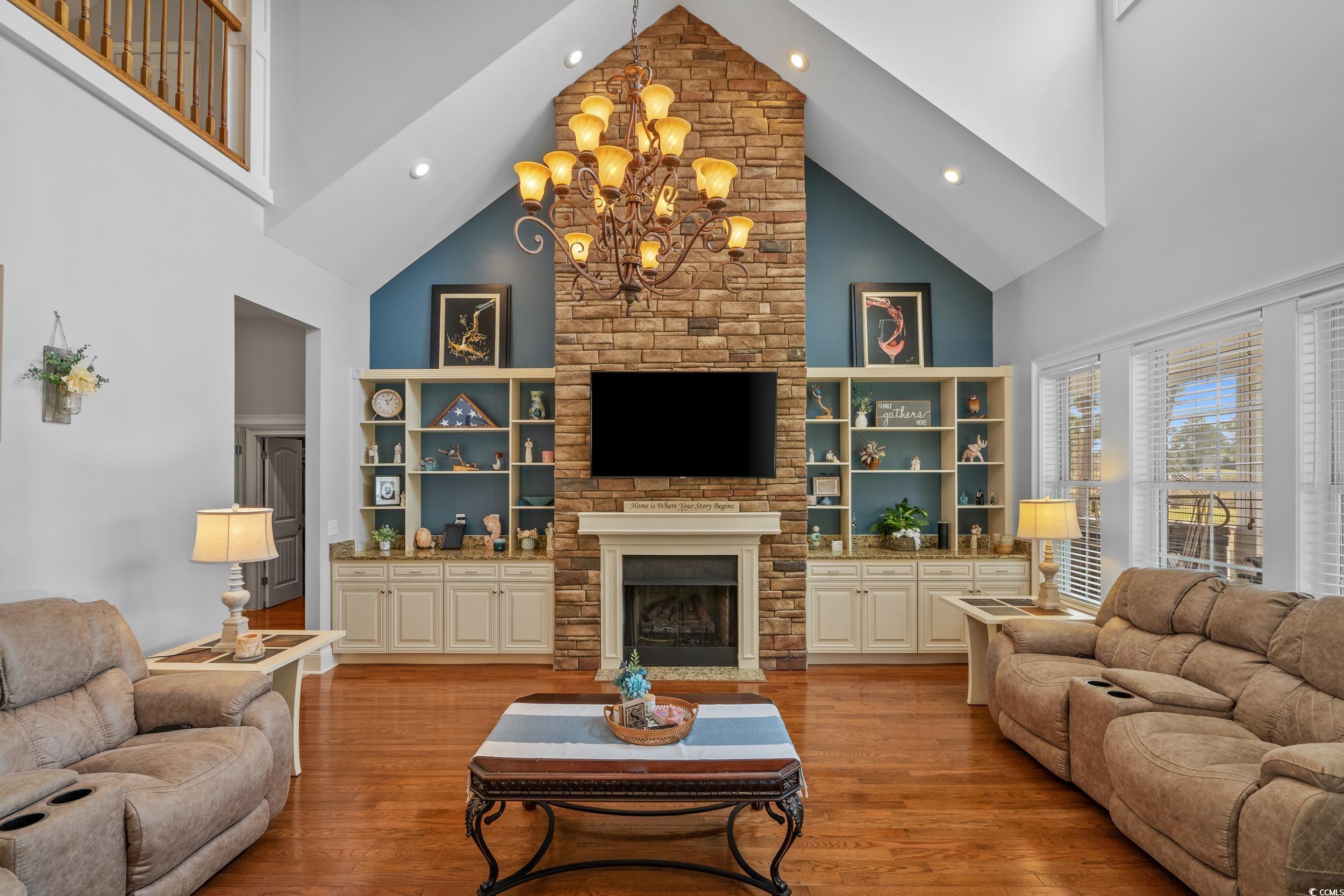 416 Seabury Lane Myrtle Beach, SC 29579 - Photo 7 of 39 Living room featuring a healthy amount of sunlight, a notable chandelier, high vaulted ceiling, and hardwood / wood-style floors