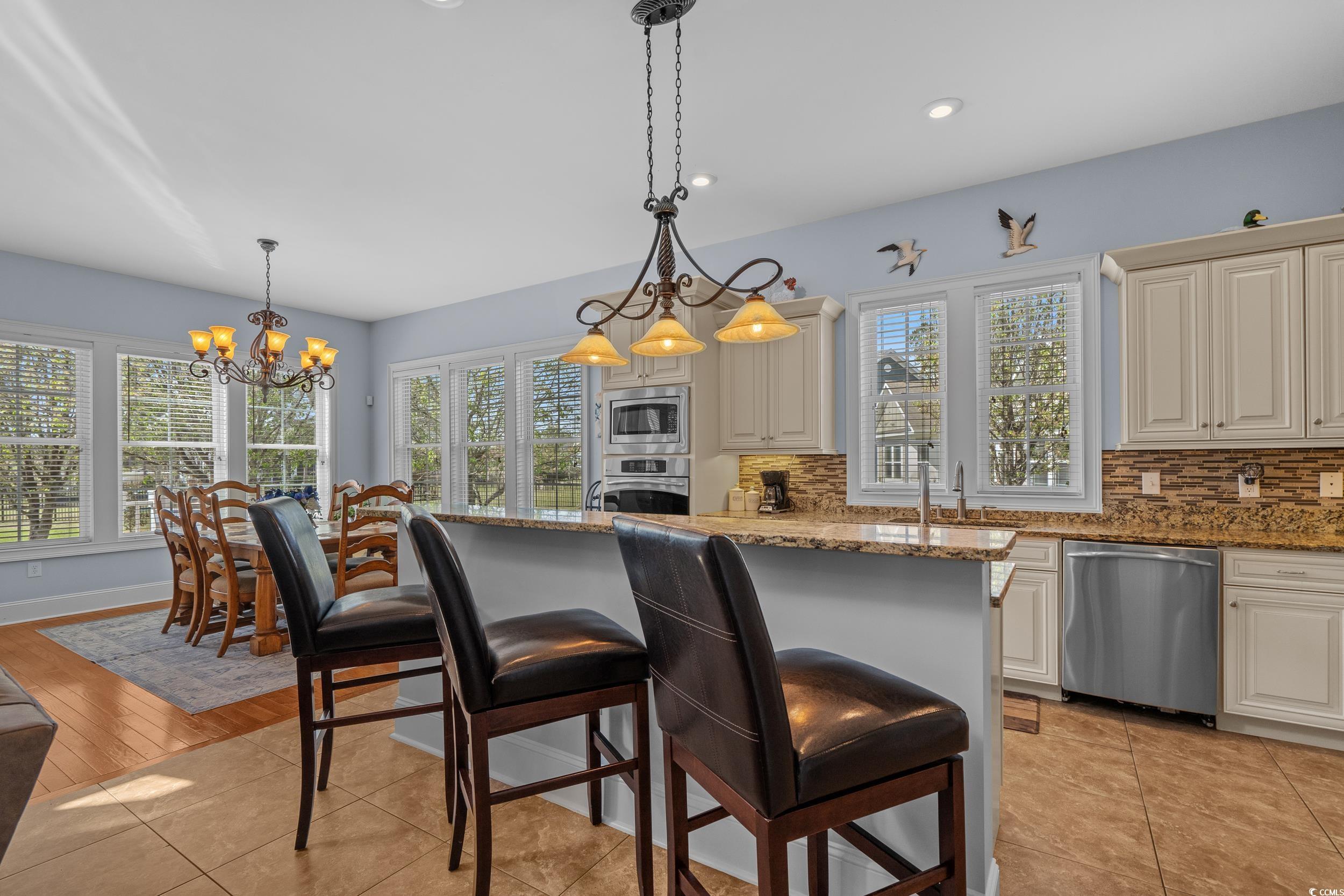 416 Seabury Lane Myrtle Beach, SC 29579 - Photo 10 of 39 Dining area with light wood-style floors, a healthy amount of sunlight, a chandelier, and visible vents