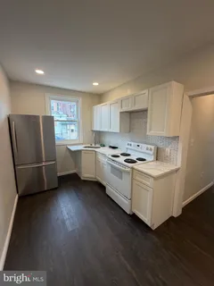 a kitchen with stainless steel appliances a refrigerator a sink a stove a microwave and cabinets