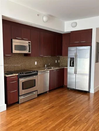 a kitchen with stainless steel appliances kitchen island granite countertop a stove a sink and a microwave