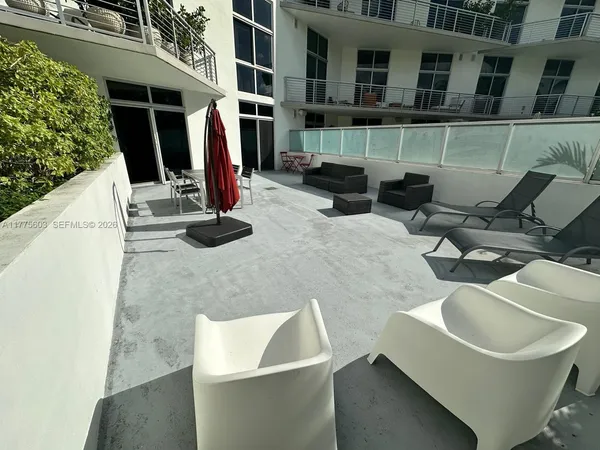 a view of roof deck with chair and tables