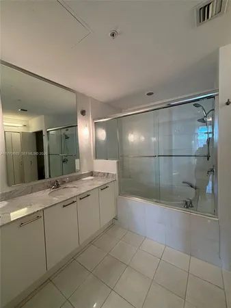a bathroom with a shower sink and mirror