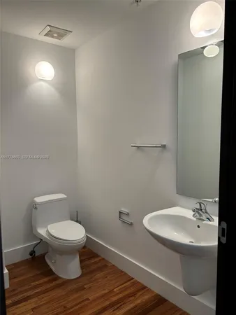 a bathroom with a toilet a sink and mirror