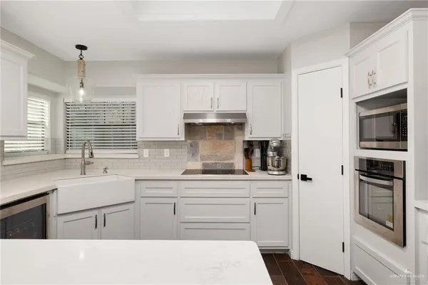 a kitchen with stainless steel appliances granite countertop a sink a stove a refrigerator and cabinets