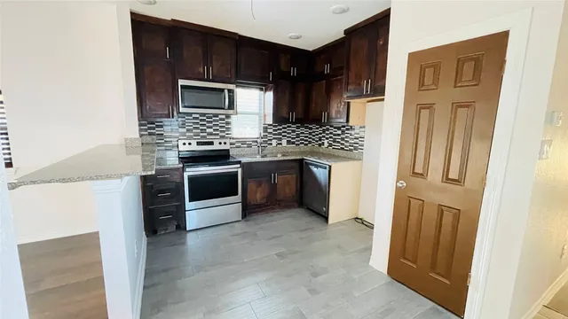 a kitchen with stainless steel appliances granite countertop a stove and a refrigerator