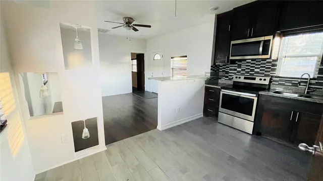 a kitchen with stainless steel appliances wooden cabinets and stove top oven