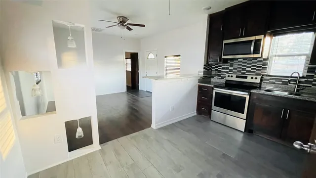 a kitchen with stainless steel appliances granite countertop a stove a microwave and a refrigerator