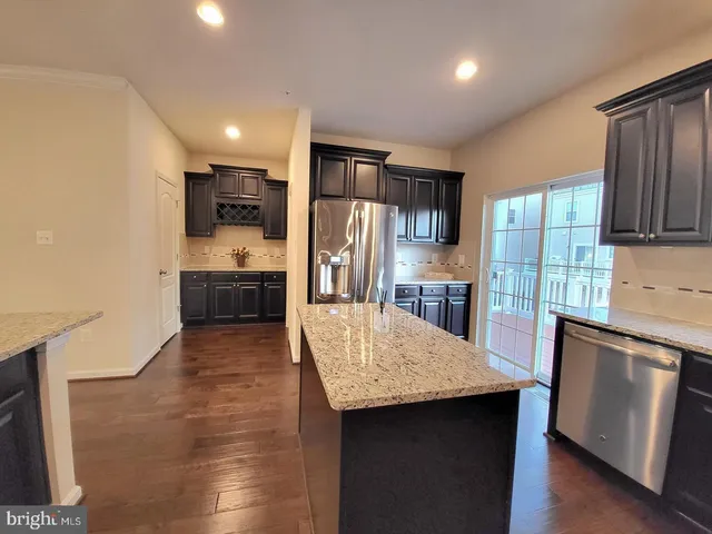 a kitchen with stainless steel appliances granite countertop a refrigerator and a stove top oven