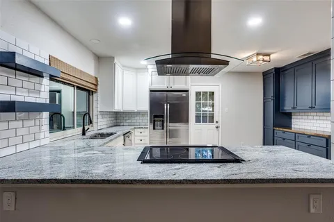 a kitchen with stainless steel appliances granite countertop a sink a stove and a wooden cabinets
