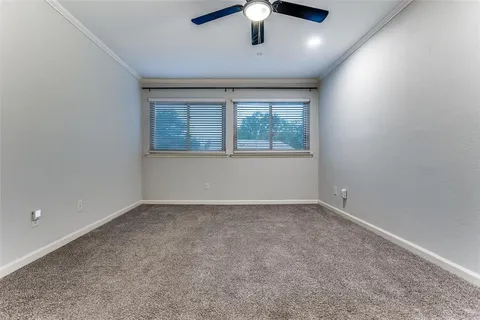 en empty room with windows and ceiling fan