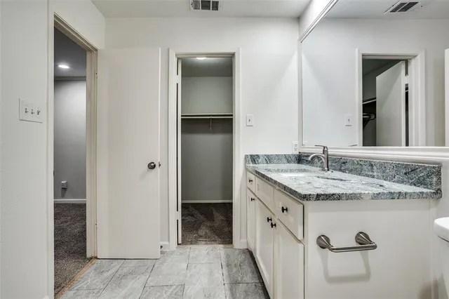 a spacious bathroom with a granite countertop sink and a mirror