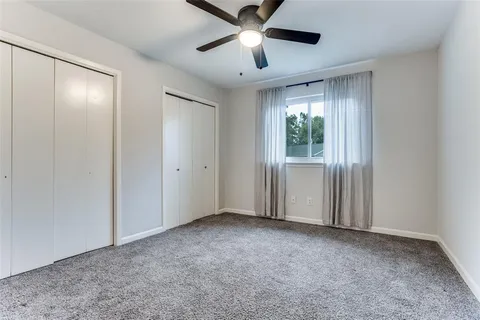 a view of empty room with window and ceiling fan