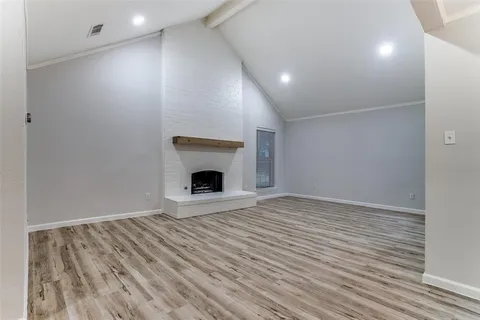 a view of empty room with wooden floor and fireplace