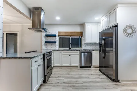 a kitchen with stainless steel appliances granite countertop a stove a sink and a refrigerator