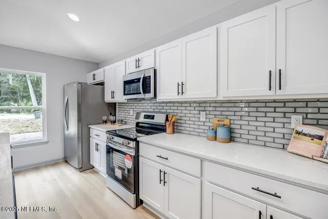 a kitchen with stainless steel appliances granite countertop a refrigerator sink and stove