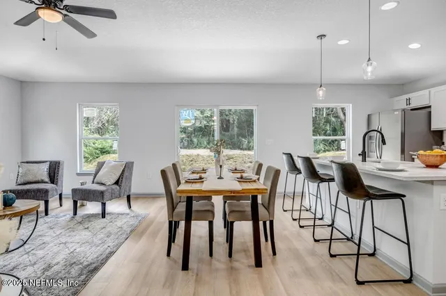 a view of a a dining room with furniture window and wooden floor