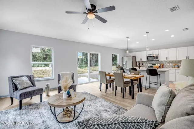 a living room with furniture a dining table and a window