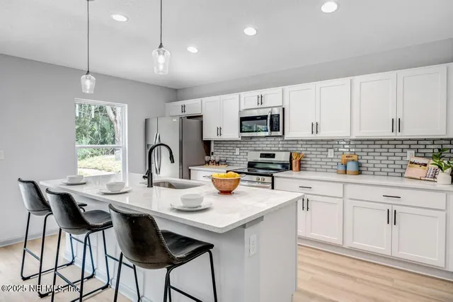 a kitchen with sink a microwave and cabinets