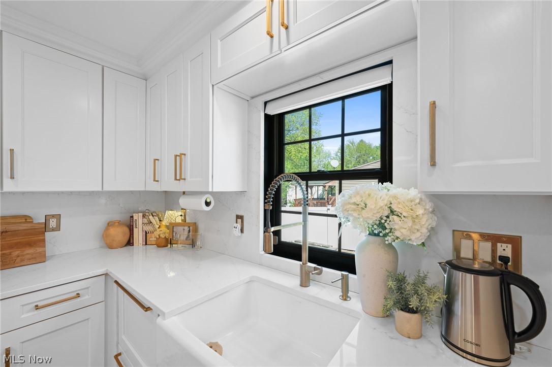 25870 Kennedy Ridge Road North Olmsted, OH 44070 - Photo 19 of 50 Bright kitchen featuring white shaker cabinetry with gold-tone hardware, white quartz countertops, and a white farmhouse sink with a gooseneck faucet