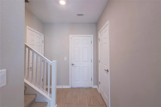 a view of a hallway with wooden floor and entryway