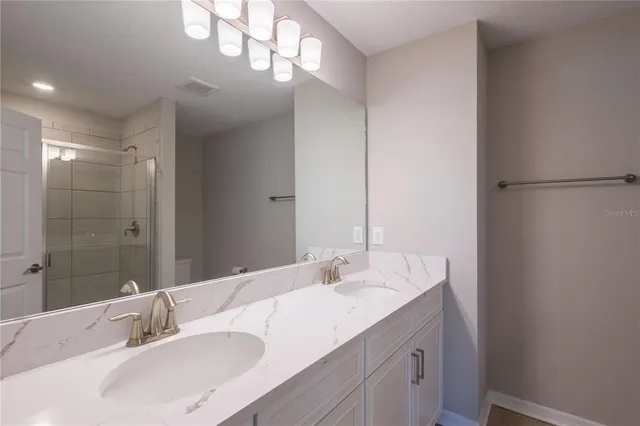 a bathroom with a sink double vanity and a mirror
