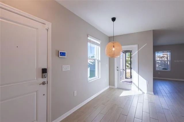 a view of a hallway with wooden floor and a chandelier
