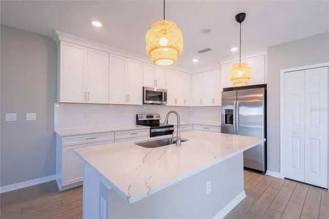 a kitchen with a sink a microwave a stove and refrigerator