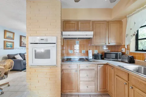a kitchen with granite countertop a sink a stove and cabinets