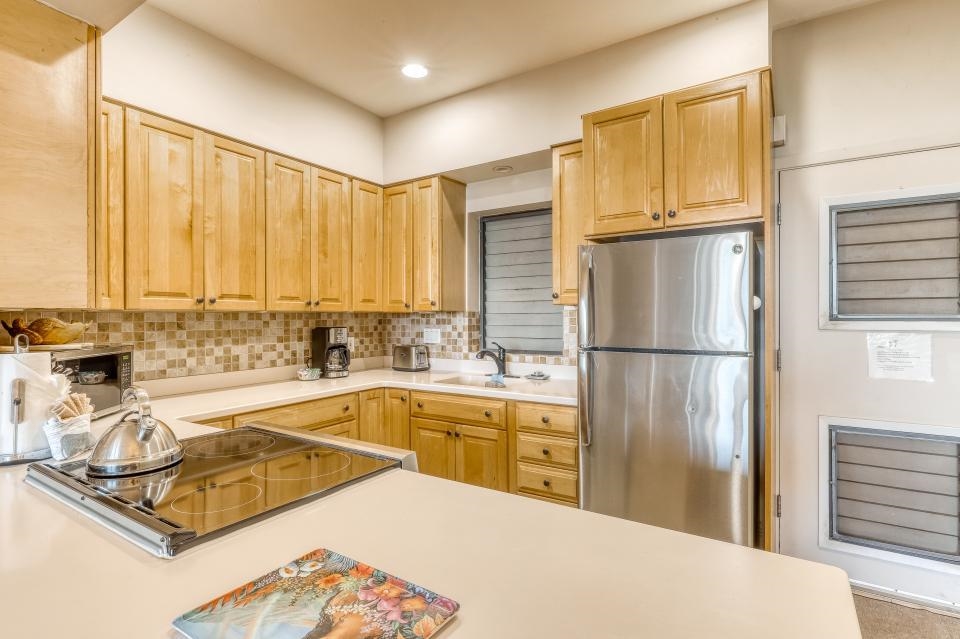 4435 Lower Honoapiilani Road, Unit 204 Lahaina, HI 96761 - Photo 11 of 26 a kitchen with stainless steel appliances granite countertop a refrigerator and a sink
