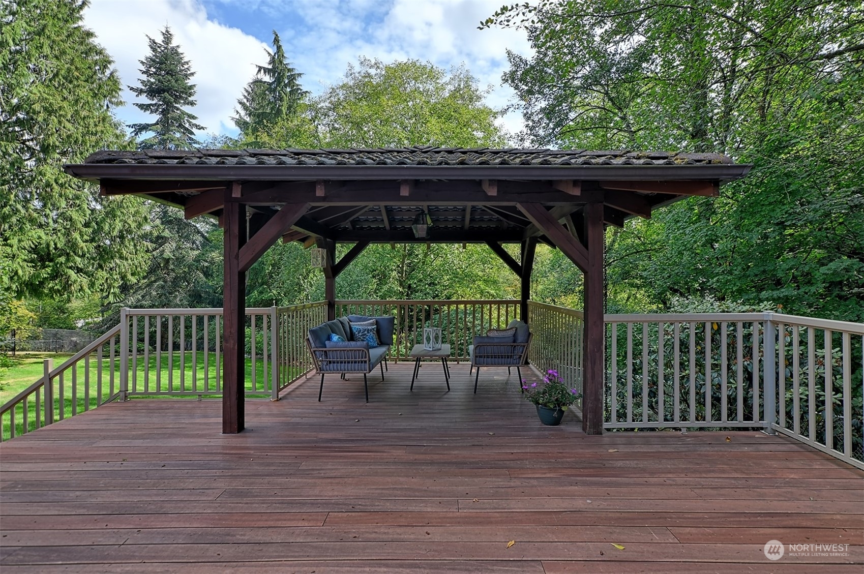 1004 218th Place Southeast Bothell, WA 98021 - Photo 18 of 30 a view of a wooden deck with a table and chairs under an umbrella