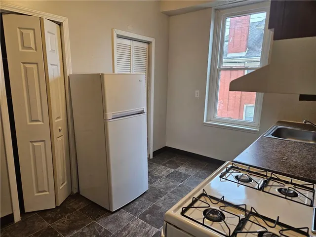 a kitchen with stainless steel appliances granite countertop a refrigerator and a stove