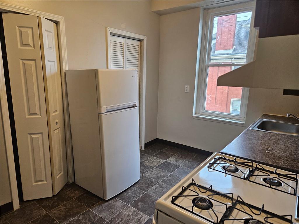 1935 Delaware Avenue, Unit 101 Pittsburgh, PA 15218 - Photo 13 of 20 a kitchen with stainless steel appliances granite countertop a refrigerator and a stove