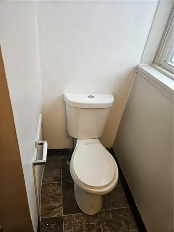 a white toilet sitting next to a small bathroom