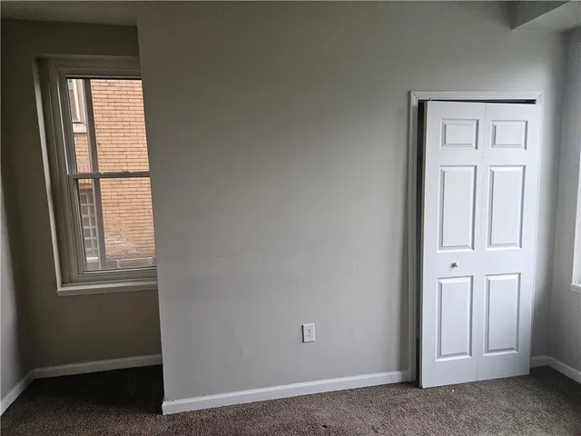 an empty room with windows and closet