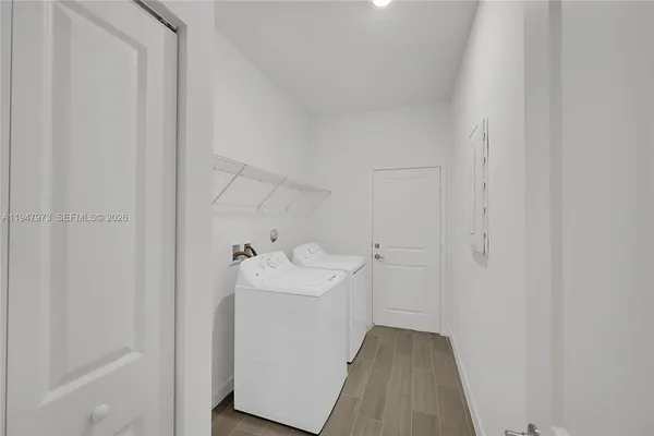 a utility room with wooden floor washer and dryer