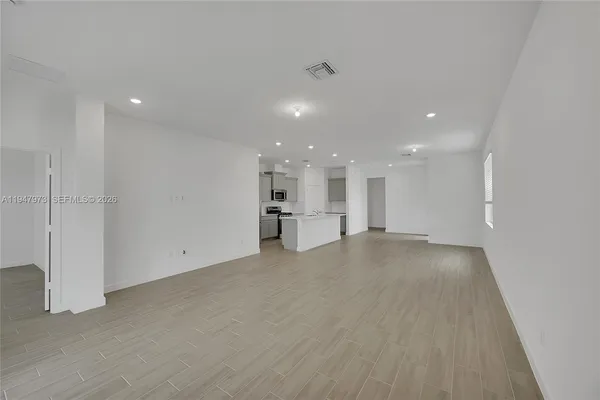 a view of a kitchen with a sink and dishwasher in white cabinet