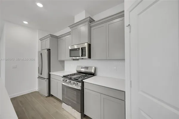 a kitchen with stainless steel appliances a refrigerator stove and microwave