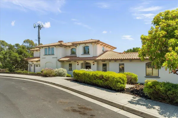 a front view of a house with a yard and potted plants