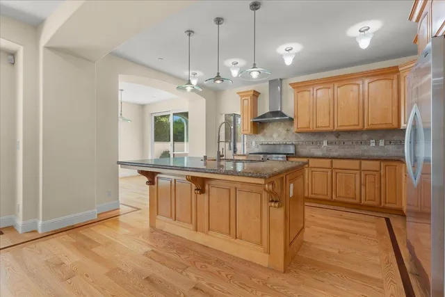 a large kitchen with stainless steel appliances granite countertop a stove a sink and a refrigerator