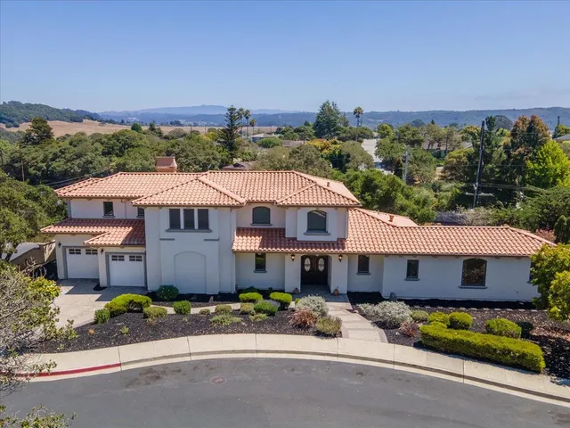 an aerial view of a house with a garden and lake view