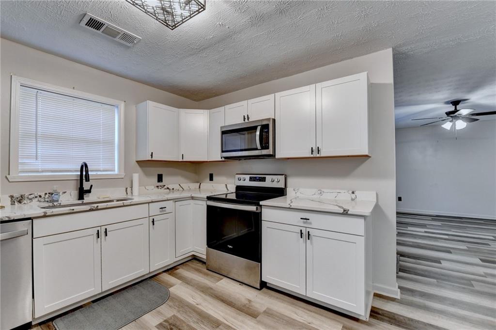 801 Davis Street Monroe, GA 30655 - Photo 12 of 33 a kitchen with a sink cabinets and wooden floor