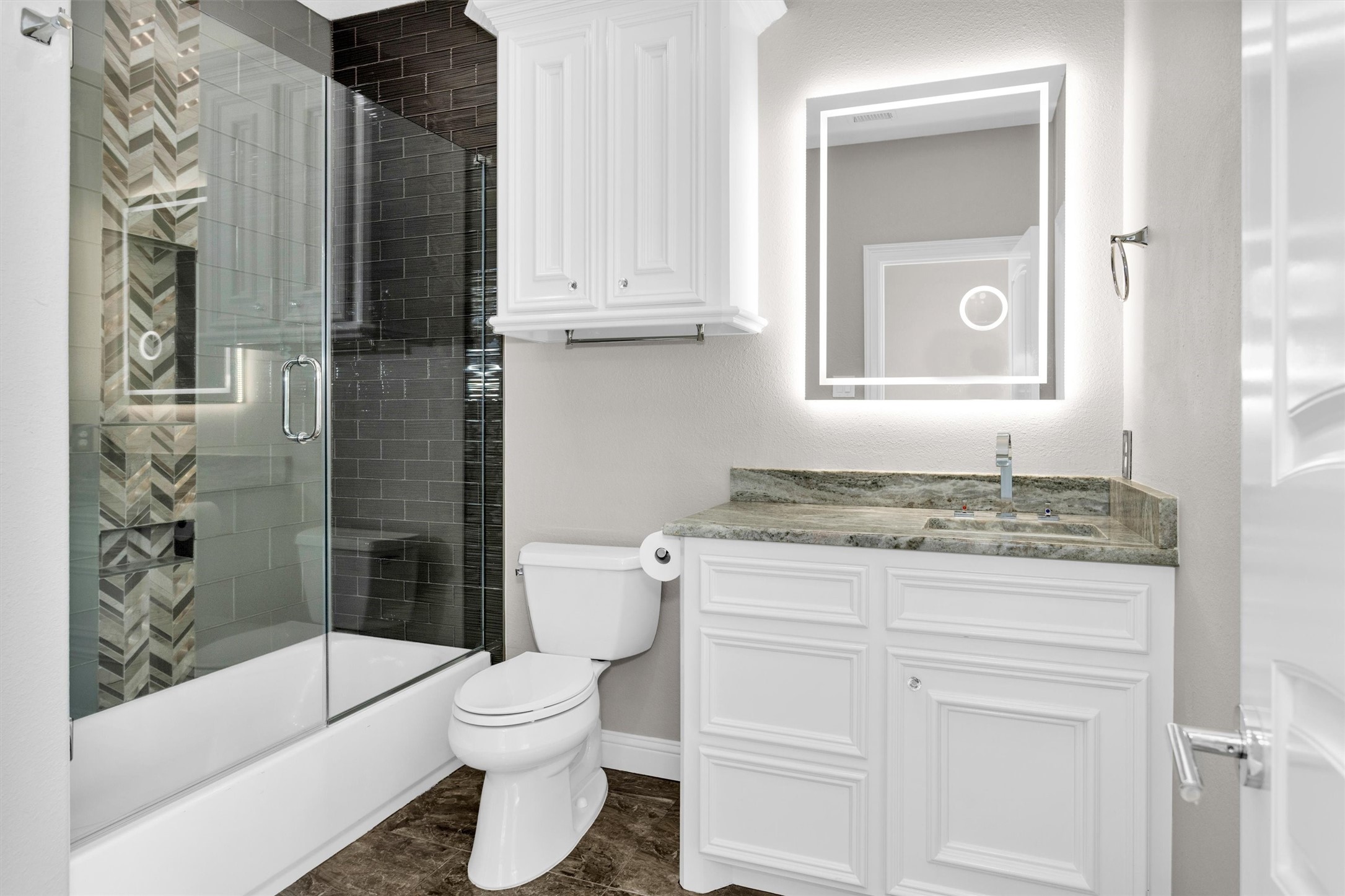 10887 Decatur Street Willis, TX 77318 - Photo 36 of 50 Each secondary bedroom is designed as a true suite with its own private bath—this one features a clean, modern finish with a frameless glass-enclosed tub/shower combo, custom tile work, and a sleek vanity with illuminated mirror.