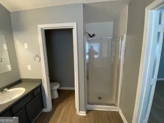a bathroom with a granite countertop shower and a toilet