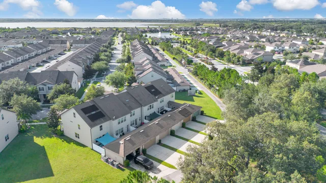 an aerial view of residential houses with outdoor space and trees
