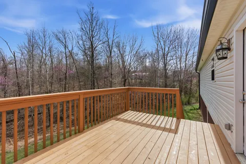 a balcony with wooden floor and trees