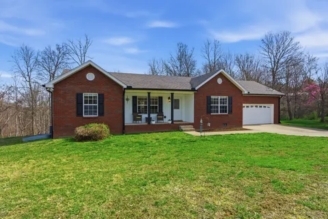 a front view of a house with yard and green space
